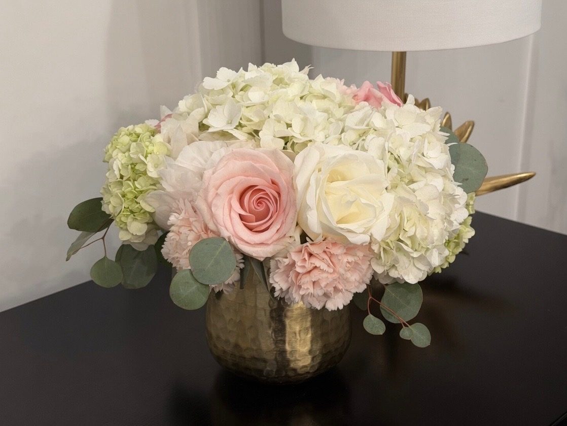Gold hammered vase of blush and white roses, pink carnations, hydrangea and eucalyptus