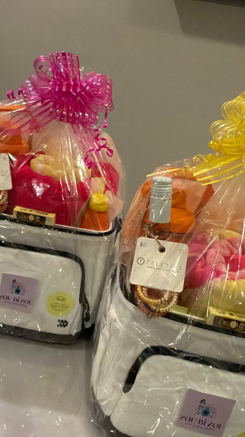 Two Zou Bi Zou cooler-bag gift baskets with towels, rosé and summer treats, wrapped with pink and yellow bows