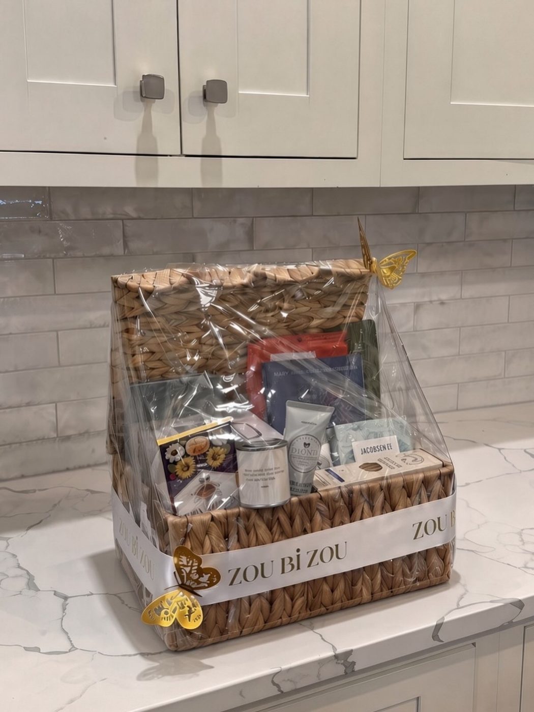 Woven gift basket wrapped with a Zou Bi Zou ribbon and gold butterflies