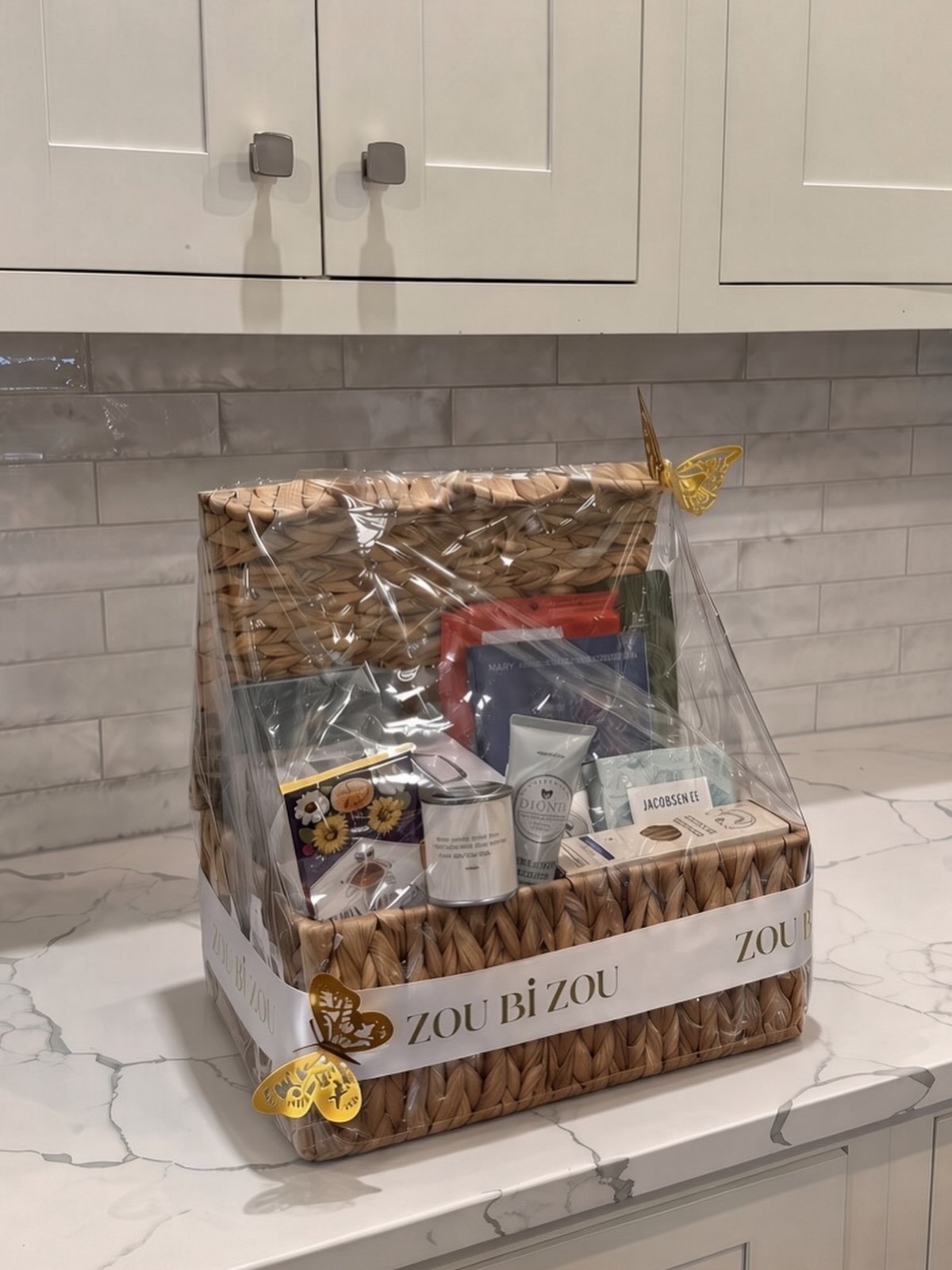 Woven gift basket wrapped with a Zou Bi Zou ribbon and gold butterflies