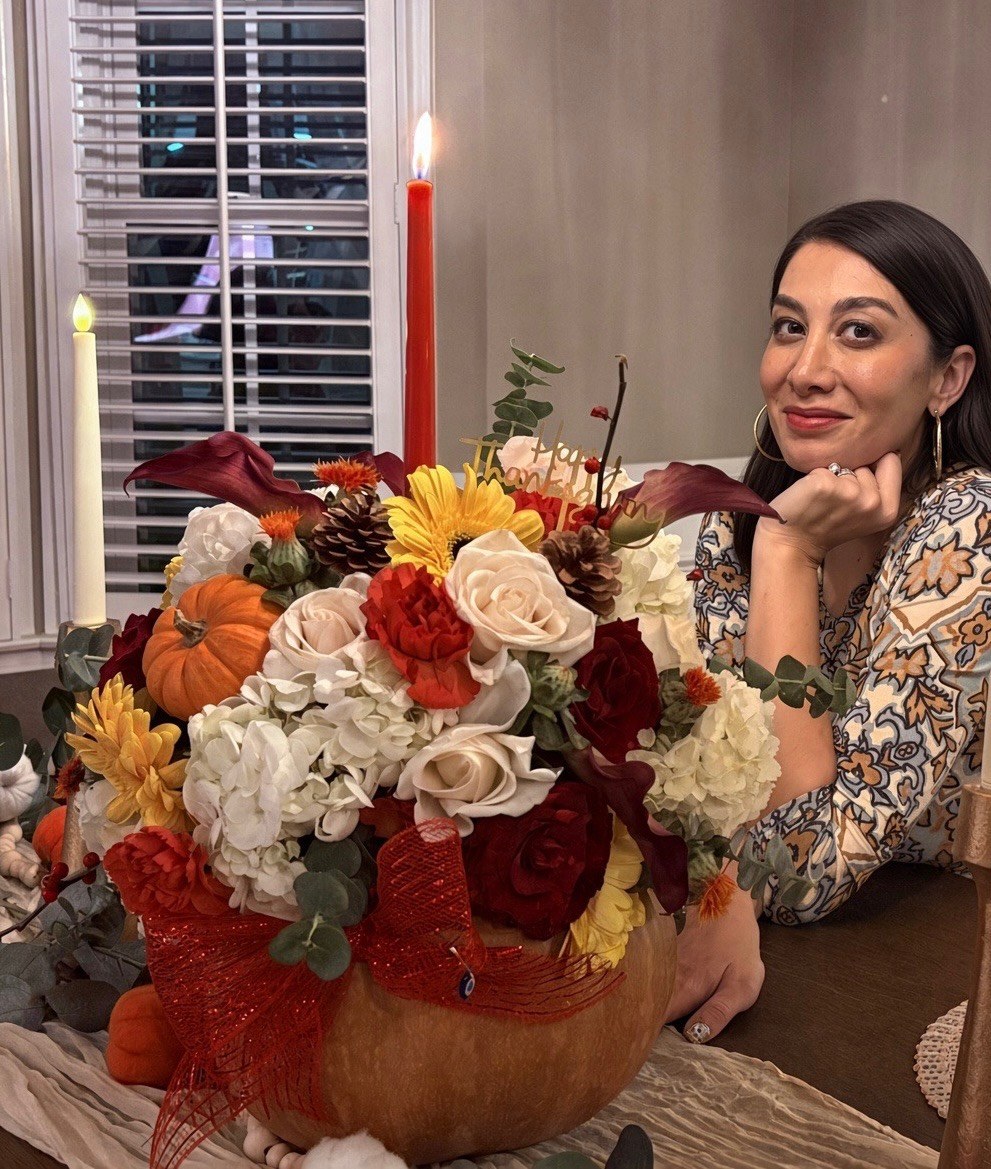 Arezou with one of her autumn floral arrangements in a pumpkin